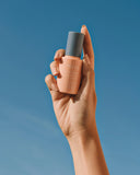 Defend Skin Restoring Serum - bottle held up against blue sky