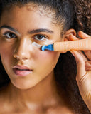 Nuria Defend Triple Action Eye Cream - woman squeezing product onto under-eye area