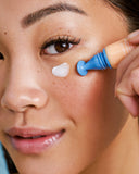 Nuria Defend Triple Action Eye Cream - woman using applicator to dispense product under eye