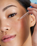 Nuria Hydrate Moisture Replenishing Serum - woman applying serum to cheek with dropper