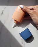 Defend Matte Finish Daily Moisturizer Mineral Sunscreen SPF 30 - bottle with lid removed showing dropper-style dispenser, product being dispensed onto marble countertop