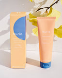Nuria Defend Gentle Exfoliator - product on counter in sun with ginkgo leaves in background