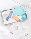 Spring Reset Kit, products displayed on a tray, a $71 value. Contains (1) Mini Defend Gentle Exfoliator, (1) Mini Calm Daily Moisturizer, (1) Mini Hydrate Revitalizing Jelly Night Treatment, (1) Hydrate Nourishing Under-Eye Masks (five pairs per pack), and (2) Kitsch Towel Scrunchies.