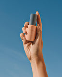 Defend Skin Restoring Serum - bottle held up against blue sky