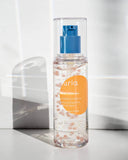 Nuria Defend Essence - bottle in front of wall showing clear product with beads