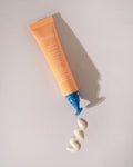 Nuria Defend Triple Action Eye Cream - tube and applicator tip next to dispensed product on countertop