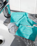 Nuria Hydrate Nourishing Under-Eye Masks - opened envelopes and pair of under-eye masks on sink, resting in crystal trays
