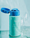 Nuria Hydrate Refreshing Micellar Water - open bottle displaying pump with reflections of water in background