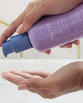 Nuria Calm Cleansing Milk -- person dispensing product into hand