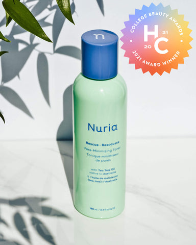 Nuria Rescue Pore-Minimizing Toner - bottle on marble counter with leaves and shadows in background, College Beauty Awards 2021 Winner