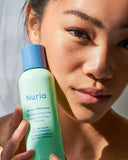 Nuria Rescue Pore-Minimizing Toner - woman holding bottle up to face in sunlight