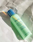 Nuria Rescue Pore-Minimizing Toner - bottle laying on crinkled paper with rainbow and shadows